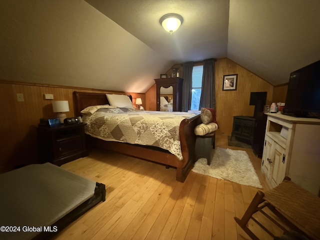 31 Wilson Ave, South Glens Falls, NY 12803 - bedroom with wooden walls, a wood stove, light wood finished floors, and lofted ceiling