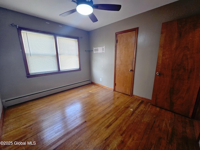 1335 Midline Rd, Amsterdam, NY 12010 - unfurnished bedroom featuring a baseboard heating unit, wood finished floors, and a ceiling fan