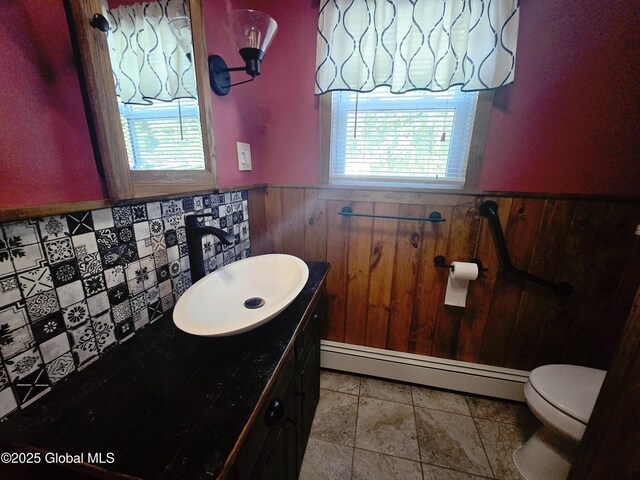 1335 Midline Rd, Amsterdam, NY 12010 - half bathroom with a baseboard heating unit, wainscoting, vanity, and wooden walls
