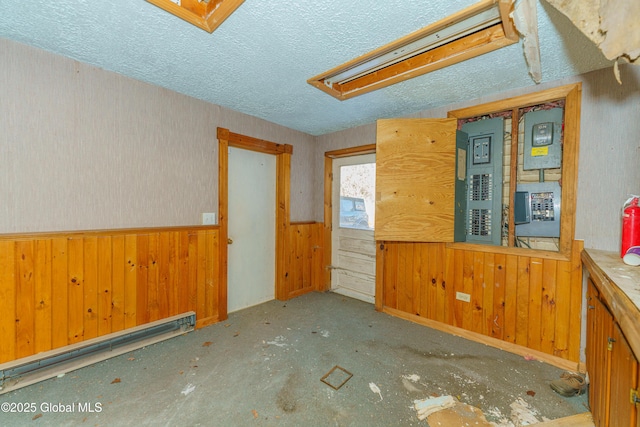 3885 Main St, Warrensburg, NY 12885 - spare room with wood walls, a wainscoted wall, and a textured ceiling