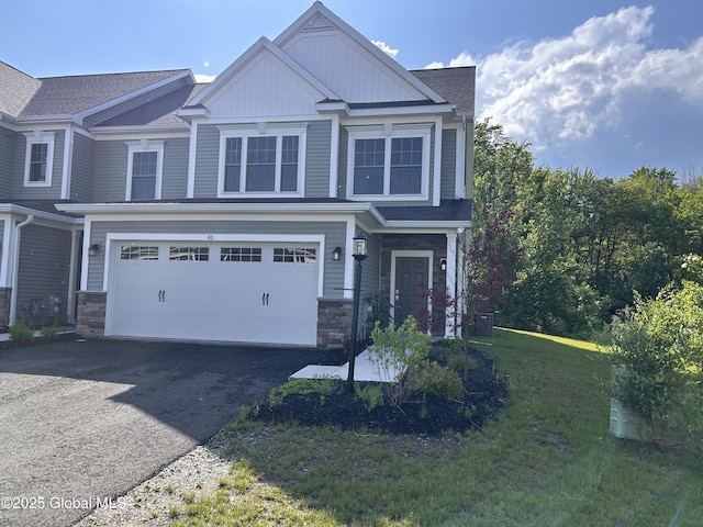 41 Hillard Ln, Colonie, NY 12110 - view of front of property with an attached garage, asphalt driveway, board and batten siding, stone siding, and a front yard