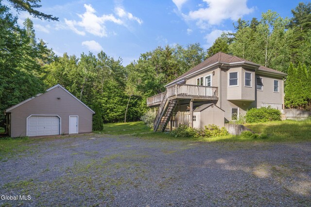 108 La Flamme Rd, Providence, NY 12850 - view of home's exterior featuring stairway, a wooden deck, a detached garage, a storage shed, and a view of trees