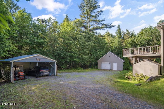 108 La Flamme Rd, Providence, NY 12850 - view of yard with a detached garage, a shed, a carport, a wooded view, and a wooden deck