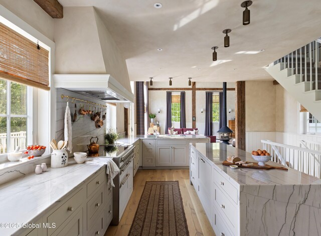1174 Potter Mountain Rd, Gilboa, NY 12076 - kitchen with a wood stove, healthy amount of natural light, light wood-type flooring, and light stone countertops