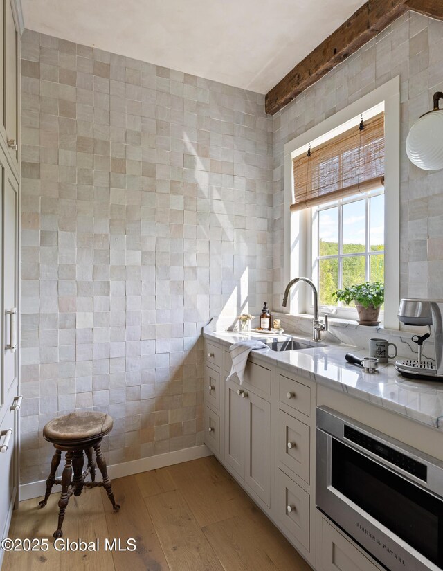1174 Potter Mountain Rd, Gilboa, NY 12076 - kitchen with tile walls, light wood-type flooring, and light stone countertops