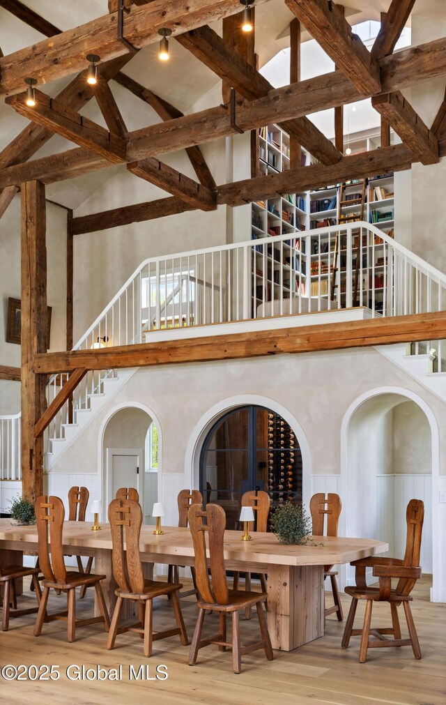 1174 Potter Mountain Rd, Gilboa, NY 12076 - dining area featuring high vaulted ceiling, stairway, wood finished floors, wainscoting, and beamed ceiling