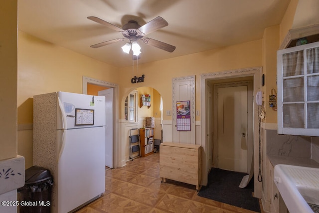 54 Wendell St, Ravena, NY 12143 - kitchen featuring freestanding refrigerator, ceiling fan, arched walkways, and a wainscoted wall