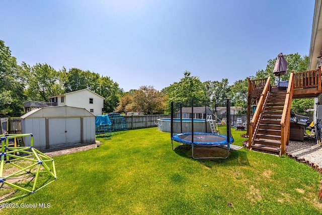 2 Moonglow Rd, Wilton, NY 12831 - fenced backyard with a storage unit, a trampoline, a wooden deck, and stairway