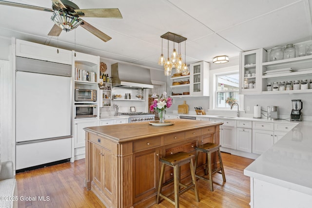 378 County Route 354, Rensselaerville, NY 12469 - kitchen with open shelves, built in appliances, wall chimney range hood, a center island, and light wood finished floors
