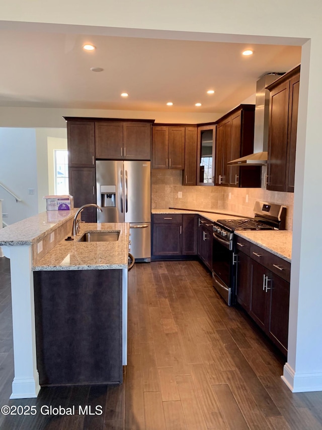 LOT17 Windrow Way, Halfmoon, NY 12118 - kitchen with stainless steel appliances, wall chimney range hood, dark brown cabinets, a center island with sink, and tasteful backsplash