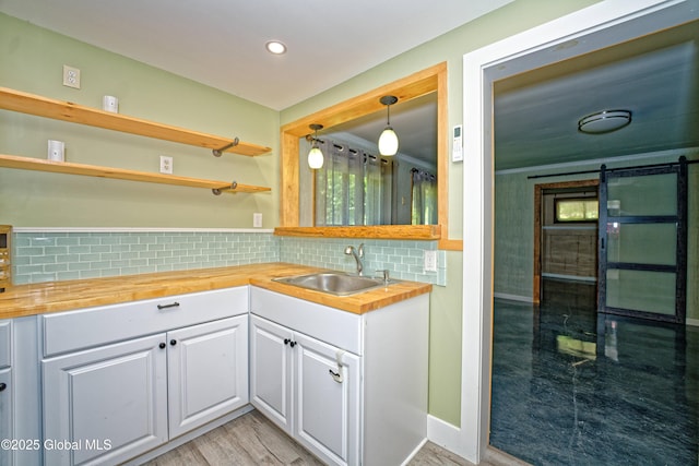 236 Colfax Rd, Jackson, NY 12816 - kitchen with butcher block counters, a barn door, white cabinets, decorative backsplash, and light wood-style flooring