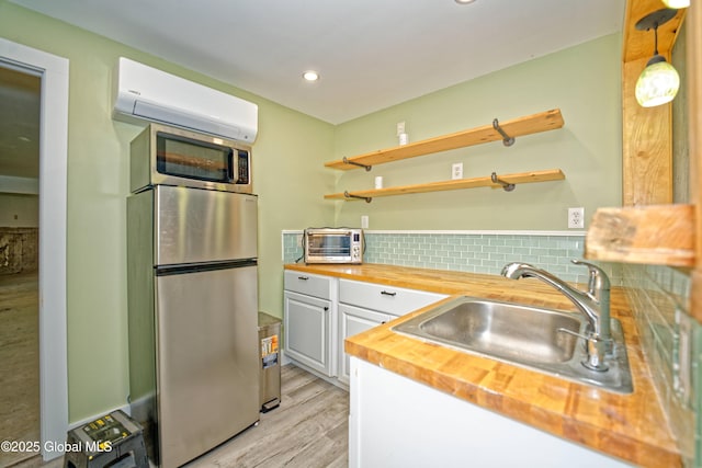 236 Colfax Rd, Jackson, NY 12816 - kitchen with stainless steel appliances, wood counters, an AC wall unit, backsplash, and light wood-style floors