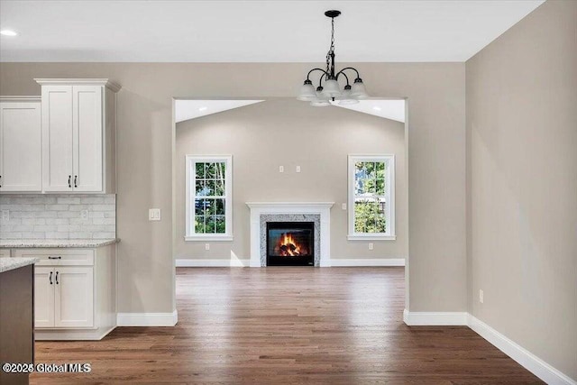 16 Surcingle Rd, Queensbury, NY 12804 - unfurnished living room featuring wood finished floors, a chandelier, a fireplace, lofted ceiling, and recessed lighting
