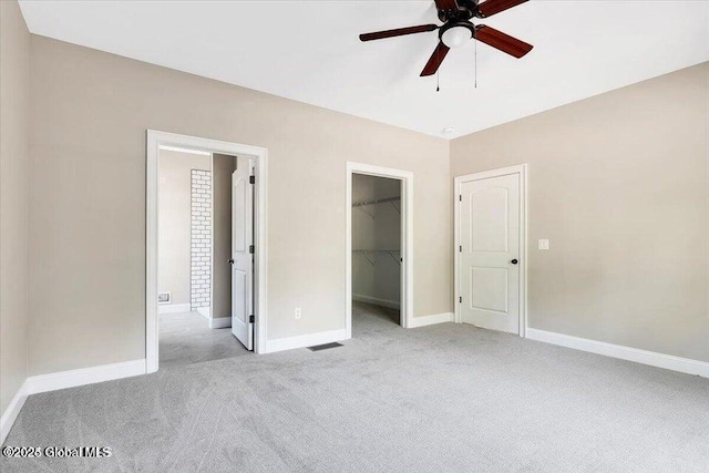 16 Surcingle Rd, Queensbury, NY 12804 - unfurnished bedroom featuring light carpet, a walk in closet, a closet, and ceiling fan