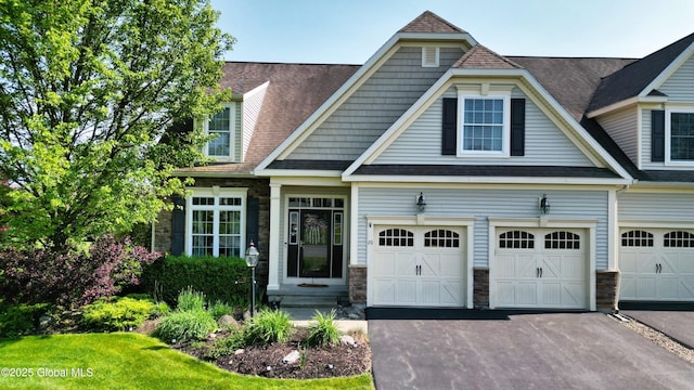 20 Beekman Pl, Queensbury, NY 12804 - view of front of house with stone siding, asphalt driveway, a shingled roof, and a garage