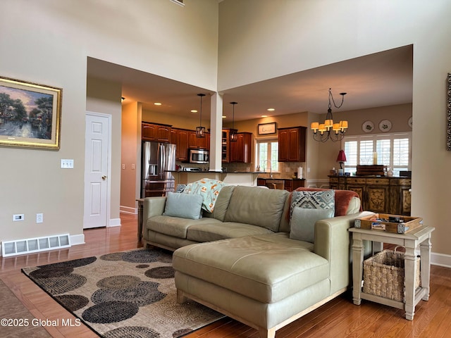 20 Beekman Pl, Queensbury, NY 12804 - living area featuring a chandelier, wood finished floors, and healthy amount of natural light