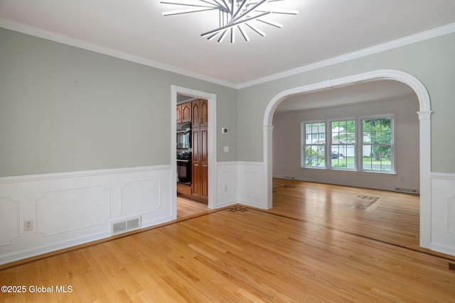 11 Boylston Dr, Bethlehem, NY 12054 - unfurnished room with arched walkways, ornamental molding, light wood-style flooring, a wainscoted wall, and a chandelier