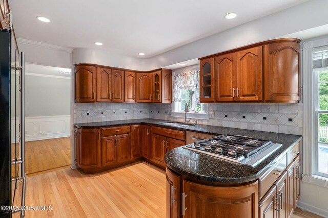 11 Boylston Dr, Bethlehem, NY 12054 - kitchen featuring stainless steel gas cooktop, brown cabinetry, light wood finished floors, dark stone countertops, and crown molding