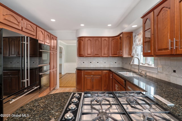 11 Boylston Dr, Bethlehem, NY 12054 - kitchen featuring high end black fridge, crown molding, dark stone countertops, light wood-style flooring, and brown cabinets