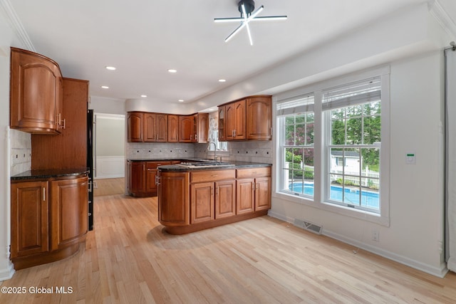 11 Boylston Dr, Bethlehem, NY 12054 - kitchen with brown cabinetry, a peninsula, light wood-style floors, decorative backsplash, and recessed lighting