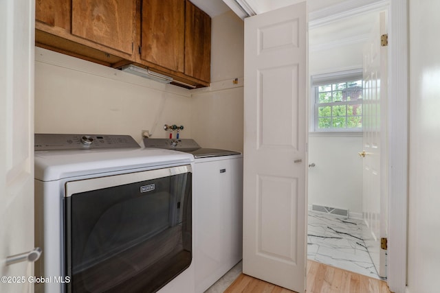11 Boylston Dr, Bethlehem, NY 12054 - laundry area featuring cabinet space, washing machine and dryer, and light wood-style floors