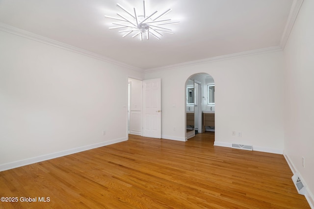 11 Boylston Dr, Bethlehem, NY 12054 - empty room with arched walkways, light wood finished floors, ornamental molding, and a chandelier
