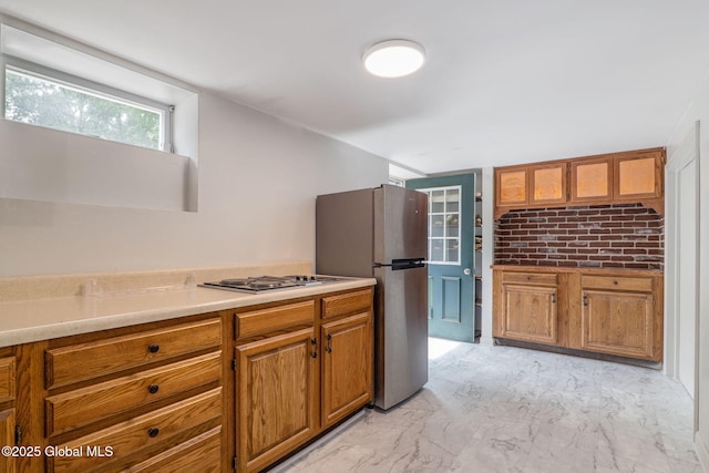 11 Boylston Dr, Bethlehem, NY 12054 - kitchen with brown cabinetry, cooktop, freestanding refrigerator, light marble finish flooring, and light countertops