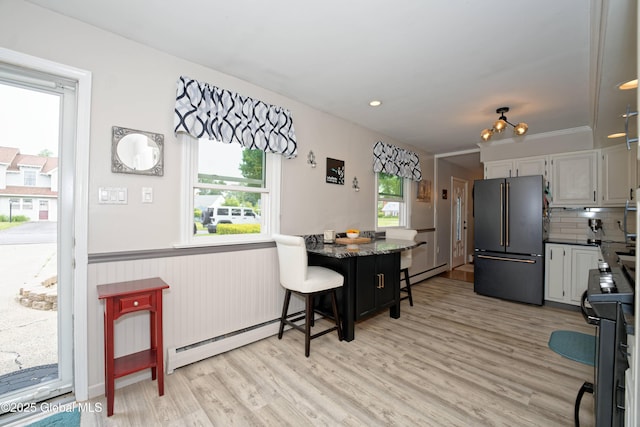 1038 Horvath St, Schenectady, NY 12303 - kitchen with freestanding refrigerator, a baseboard heating unit, light wood-style flooring, a breakfast bar, and stove