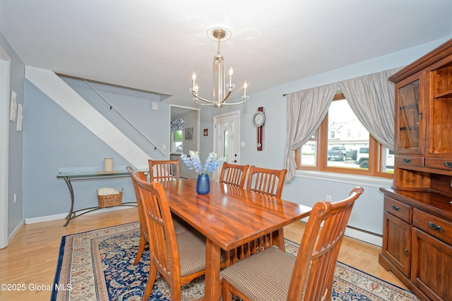 1038 Horvath St, Schenectady, NY 12303 - dining area featuring a baseboard heating unit, stairway, light wood-style flooring, and a chandelier
