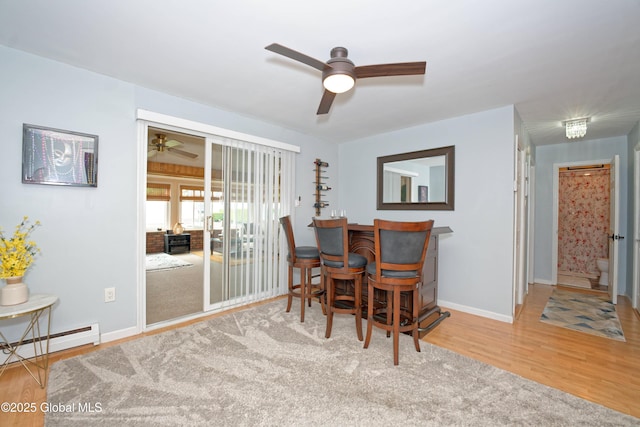 1038 Horvath St, Schenectady, NY 12303 - dining space featuring a ceiling fan, a baseboard heating unit, wood finished floors, and a dry bar