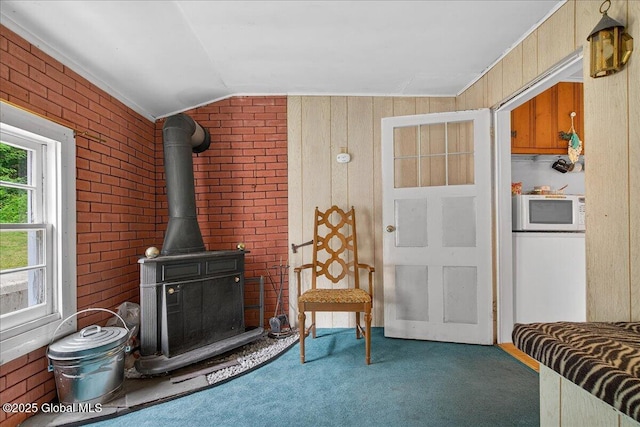 579 Camden Valley Rd, Salem, NY 12873 - living room with carpet flooring, a wood stove, vaulted ceiling, brick wall, and wood walls