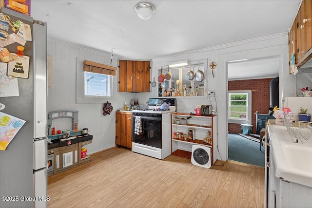 579 Camden Valley Rd, Salem, NY 12873 - kitchen with freestanding refrigerator, white range with gas cooktop, brown cabinets, light wood-style floors, and ornamental molding