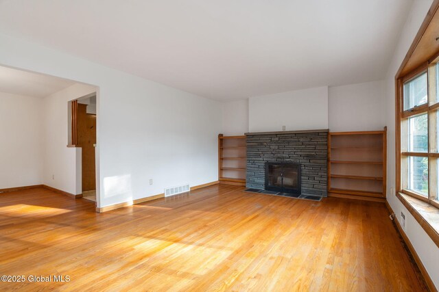 11 Drawbridge Dr, Guilderland, NY 12203 - unfurnished living room featuring light wood-style flooring and a fireplace