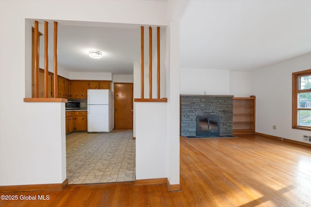 11 Drawbridge Dr, Guilderland, NY 12203 - unfurnished living room with a stone fireplace and light wood-type flooring