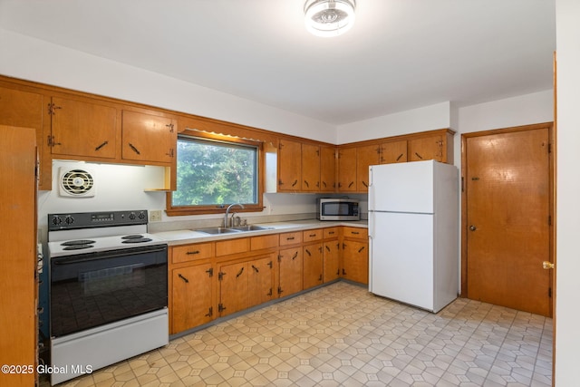 11 Drawbridge Dr, Guilderland, NY 12203 - kitchen with freestanding refrigerator, electric range, stainless steel microwave, light countertops, and brown cabinetry