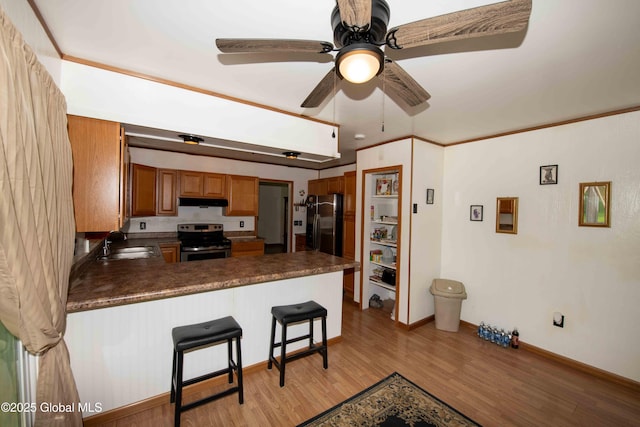 22 Elm Lane Ext, Westerlo, NY 12083 - kitchen with electric range, a peninsula, light wood-style flooring, dark countertops, and brown cabinetry