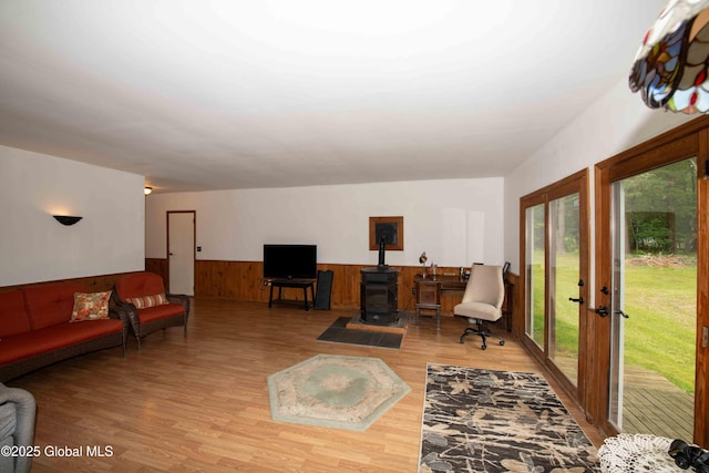 22 Elm Lane Ext, Westerlo, NY 12083 - living area with wainscoting, light wood-style floors, a wood stove, wooden walls, and french doors