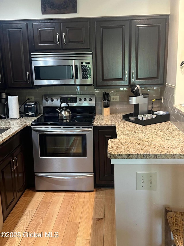 110 Sagamore Rd Unit 6B5, Bolton, NY 12814 - kitchen with stainless steel appliances, tasteful backsplash, light stone counters, and light wood finished floors
