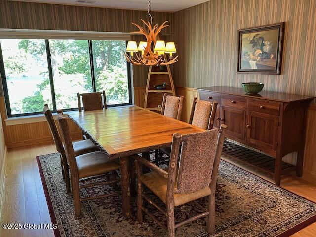 110 Sagamore Rd Unit 6B5, Bolton, NY 12814 - dining area with a chandelier, wallpapered walls, and light wood finished floors