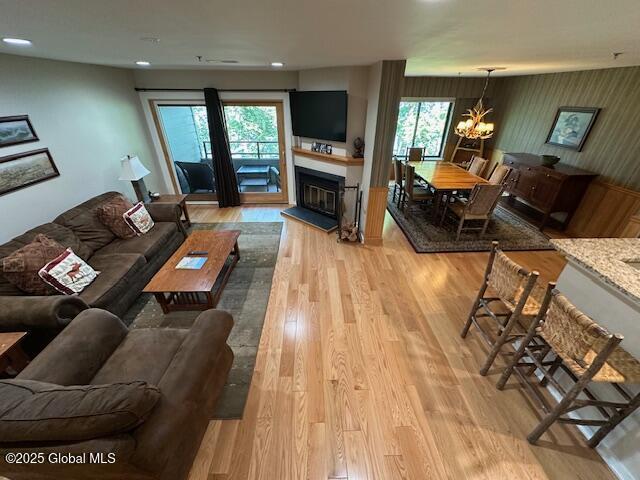 110 Sagamore Rd Unit 6B5, Bolton, NY 12814 - living area with light wood-type flooring, healthy amount of natural light, recessed lighting, a chandelier, and a glass covered fireplace