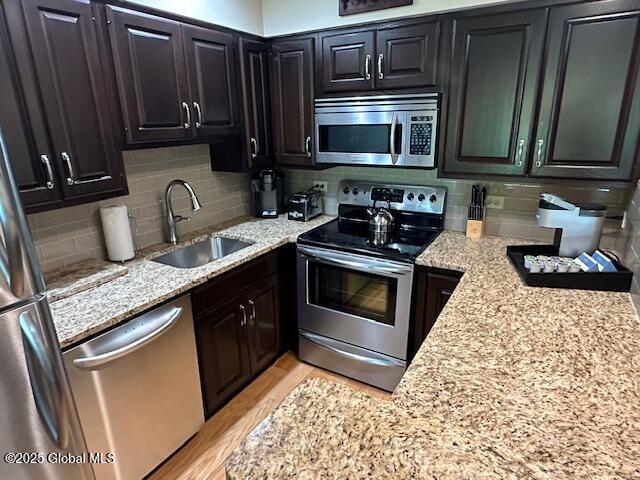110 Sagamore Rd Unit 6B5, Bolton, NY 12814 - kitchen featuring stainless steel appliances, backsplash, and light stone countertops
