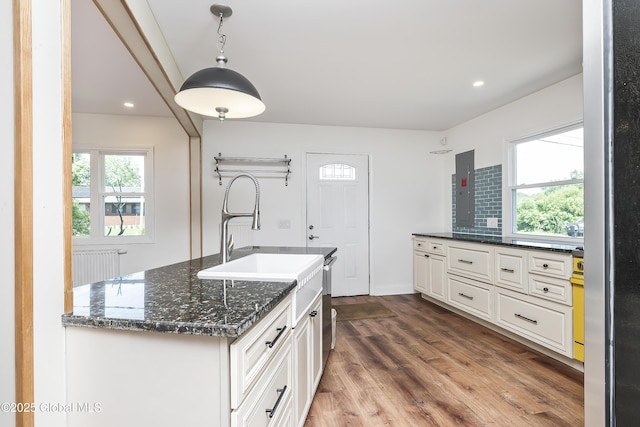 35 Magee Dr, Bethlehem, NY 12077 - kitchen featuring dark stone countertops, dark wood-style floors, white cabinets, stainless steel dishwasher, and hanging light fixtures