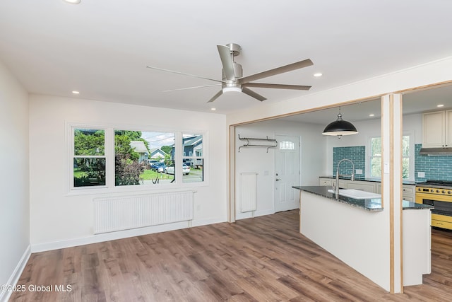 35 Magee Dr, Bethlehem, NY 12077 - kitchen with radiator heating unit, high end stove, dark countertops, wood finished floors, and recessed lighting