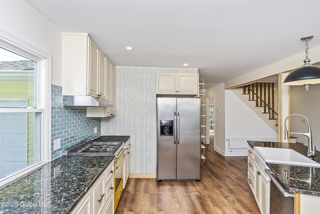 35 Magee Dr, Bethlehem, NY 12077 - kitchen featuring appliances with stainless steel finishes, wood finished floors, pendant lighting, dark stone countertops, and backsplash