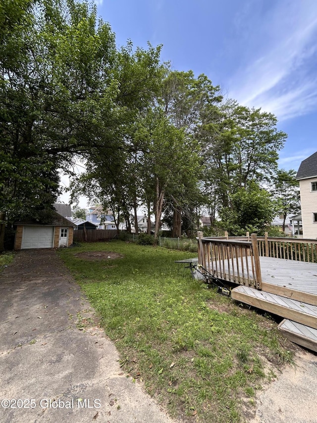 528 Harrison Ave, Schenectady, NY 12306 - view of yard featuring a deck, driveway, a garage, and an outbuilding