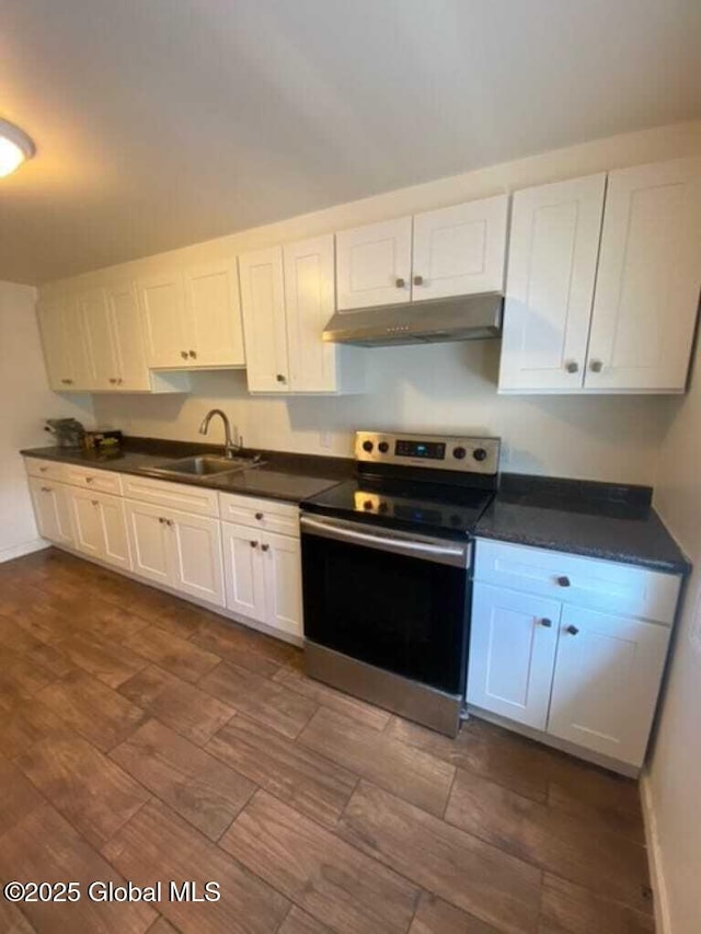 18 Railroad Ave, Berlin, NY 12022 - kitchen with electric stove, under cabinet range hood, dark countertops, white cabinets, and dark wood-type flooring
