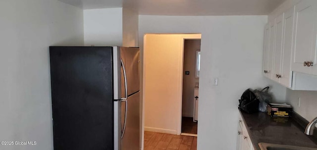 18 Railroad Ave, Berlin, NY 12022 - kitchen featuring freestanding refrigerator, light wood-style flooring, white cabinets, and dark countertops