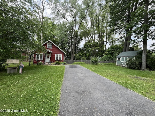 143 Marriott Ave, Schenectady, NY 12304 - view of front of house featuring asphalt driveway, a storage unit, and view of wooded area