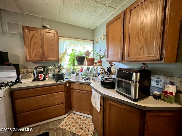 143 Marriott Ave, Schenectady, NY 12304 - kitchen with white range with gas cooktop, brown cabinetry, and light countertops