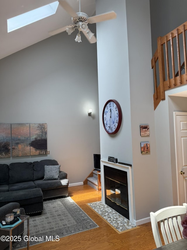 7048 Suzanne Ln, Guilderland, NY 12303 - living area with high vaulted ceiling, a skylight, a ceiling fan, and wood finished floors
